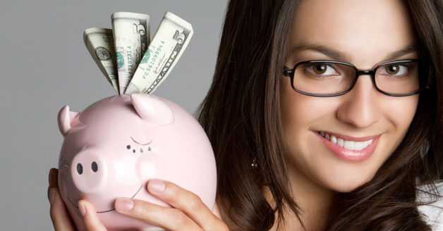 Woman wearing glasses holding a piggy bank of money