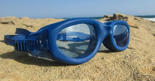Swimming goggles resting on sand