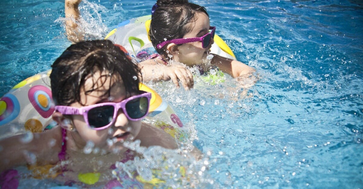 Kids wearing sunglasses playing in a pool