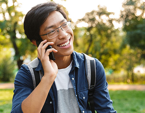 Man on phone smiling wearing polycarbonate lenses