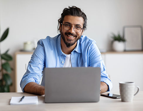 Man with laptop using blue-light lenses