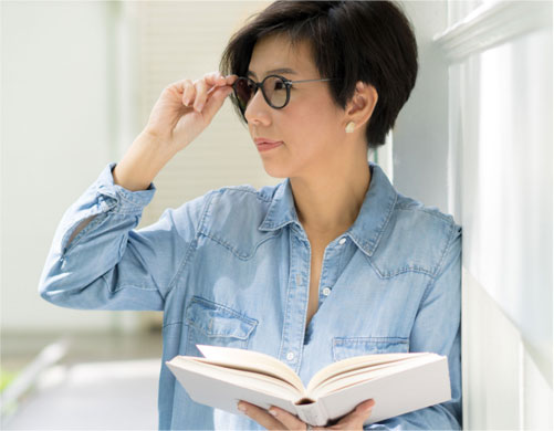Woman wearing glasses holding a book