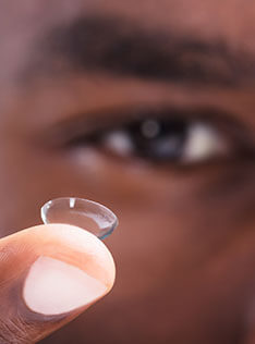 Man holding out a contact lens