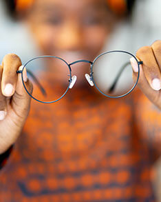 Girl holding out eyeglasses