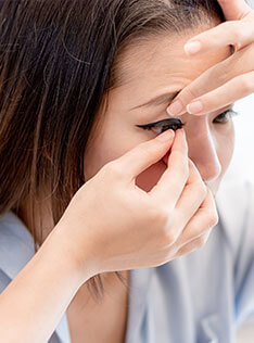 Woman taking off contact lens