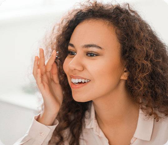 Woman with curly hair putting on contact lens