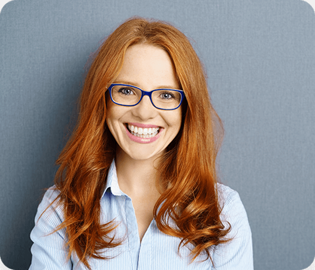 Woman with red hair wearing glasses smiling