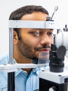 Man undergoing a comprehensive eye health exam in Bard Optical Quincy